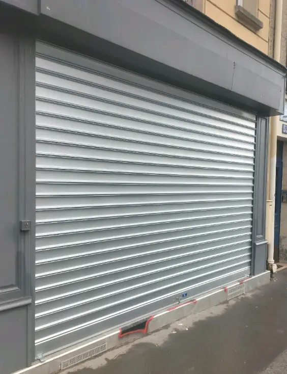 Tablier de rideau métallique remplacé en lames pleines après intervention HBHS à Paris 20