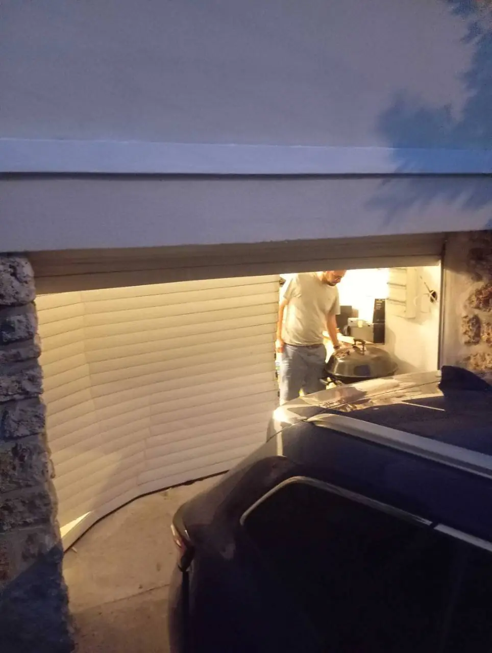 avant: porte de garage endommagée après un choc de voiture