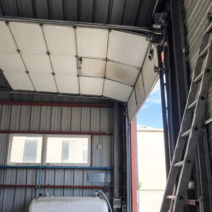 Porte sectionnelle industrielle bloquée en position ouverte avant intervention HBHS à Antony (92)